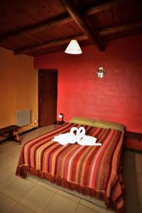 乌玛瓦卡Cabaña Kenty Wasy的红色卧室,床上有白色的带子