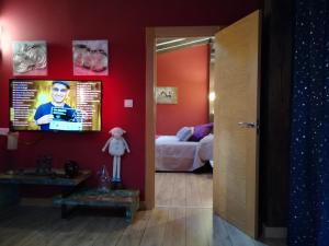 Ormas波萨达欧玛思旅馆的一间配有电视的房间和一间配有一张床的卧室