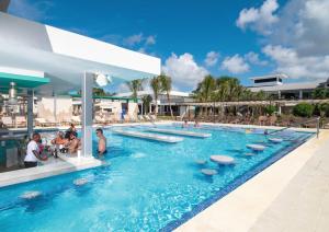 尼格瑞尔Riu Palace Tropical Bay - All Inclusive的度假村的游泳池,有人坐在里面