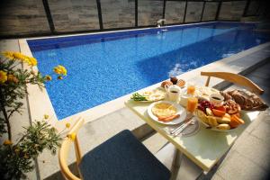 科布列季Chveni Ezo Boutique Hotel的游泳池畔的早餐桌