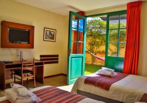 卡哈马卡Hotel Tartar的一间卧室设有两张床、一张桌子和一个窗口。