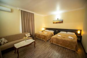科布列季Hotel Chveni Ezo的酒店客房,设有两张床和一张沙发