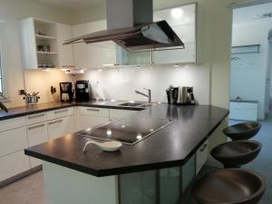 凯尔克海姆Luxus Wohnung in der Nähe von Frankfurt的厨房配有带水槽和凳子的柜台。