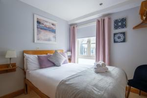 戈尔韦艾尔广场联排别墅酒店的一间卧室配有一张床,床上有毛巾