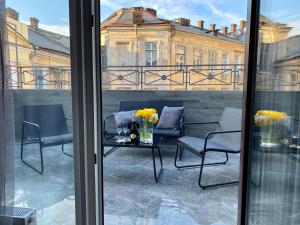 敖德萨Kuprin Hotel的阳台配有椅子和鲜花桌子。