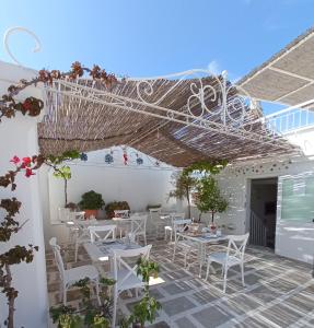 莫诺波利旧门住宿加早餐旅馆的庭院配有白色的桌子和白色的椅子。