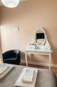 奥埃拉斯7 Castelos的一间卧室配有一张带镜子和椅子的桌子