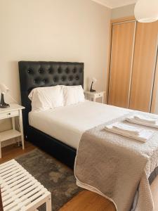 奥埃拉斯7 Castelos的一间卧室配有一张大床和黑色床头板
