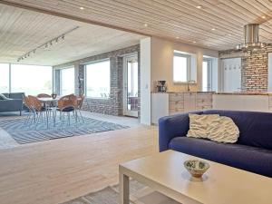 斯瓦讷克6 person holiday home in Svaneke的客厅配有蓝色的沙发和桌子