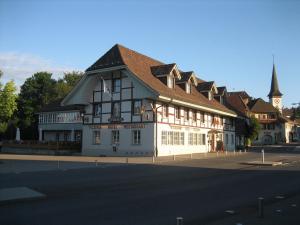 伯尔尼Hotel & Restaurant Sternen Köniz bei Bern的一条白色的大建筑,在街上有棕色的屋顶