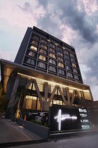 三宝垄Awann Sewu Boutique Hotel and Suite Semarang的前面有标志的高楼