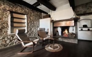 圣马力诺La casa di Montegiardino的客厅配有两把椅子和壁炉