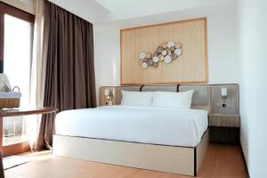 Maratua AtollArasatu Villas & Sanctuary的卧室配有白色的床和窗户。