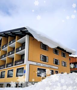 上陶恩Hotel Bella的雪地中的一座建筑