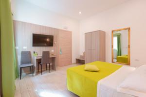卡利亚里Bardilio Luxury Rooms的一间卧室配有一张床、一张书桌和一台电视