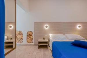 卡利亚里Bardilio Luxury Rooms的一间卧室配有蓝色的床和两张桌子