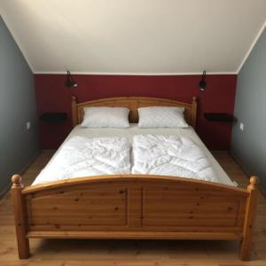 蒂萨菲赖德Hanga Apartman的一间卧室配有一张带两个枕头的木床