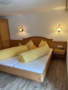索尔登Rimls Landhaus的一间卧室配有一张带枕头的木床