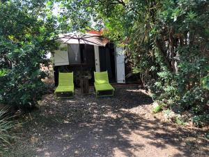 巴斯特尔Le Laurier Rose的两把绿色椅子坐在房子前面