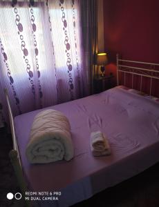 里托楚伦La betia的一张带白色毯子的床和两张毛巾