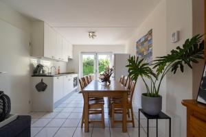 奥德多普Holiday home Zuiderdiep 6 Noordzeepark - Ouddorp, near the beach - not for companies的厨房以及带桌椅的用餐室。