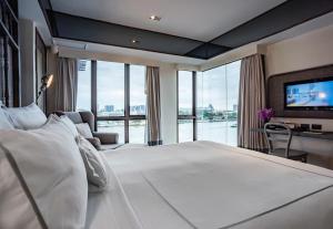 曼谷曼谷里瓦苏里亚酒店 - SHA Extra Plus的卧室设有一张大白色的床和大窗户