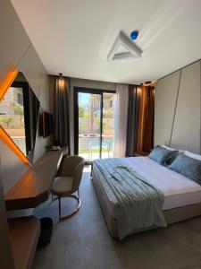 切什梅Enso Alaçatı的一间卧室配有一张床、一张书桌和一个窗户。