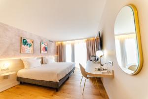 曼德琉-拉纳普勒Ilot du Golf BW Premier Collection的酒店客房带一张床、一张书桌和一面镜子