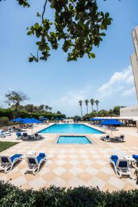 拉斯阿尔卡麦BM Beach Hotel的一个带躺椅和 ⁇ 板的游泳池
