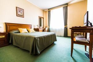 罗兹Stacja Nowa Gdynia Bed & Breakfast的配有一张床和一张书桌的酒店客房