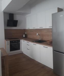 埃尔布隆格Apartamenty Irena Stare Miasto Św. Ducha的厨房配有白色橱柜和不锈钢冰箱