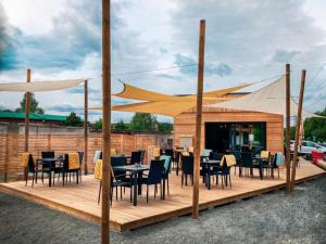 瓦拉什斯凯梅济日奇Sport HOTEL Bečva的木甲板上设有桌椅的餐厅