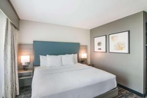 贝克斯菲尔德Hourglass Hotel, Ascend Hotel Collection的卧室配有一张白色大床和两盏灯。