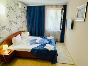 尼普顿旅行者酒店的酒店客房带蓝色床单和窗户。