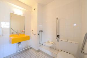 塔布肯尼迪会展公园酒店的一间带黄色水槽和卫生间的浴室