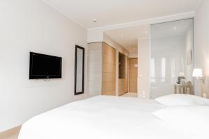 日内瓦Starling Hôtel Résidence Genève的卧室配有一张床,墙上配有电视。