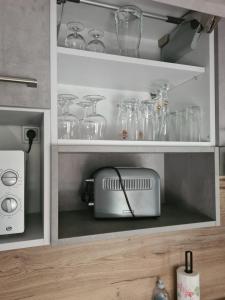 朗巴克Gîte le petit bûcheron的厨房架,配有玻璃罐和烤面包机