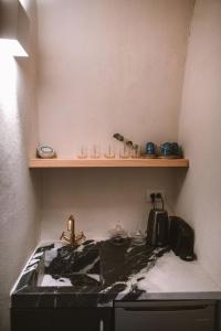 伊亚Spitia Santorini Villa Collection的厨房柜台设有水槽和架子
