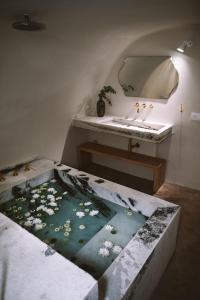 伊亚Spitia Santorini Villa Collection的浴室配有盥洗盆和浴缸。