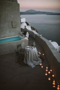 伊亚Spitia Santorini Villa Collection的游泳池畔的一张带蜡烛的桌子
