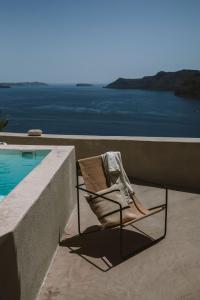 伊亚Spitia Santorini Villa Collection的游泳池旁的躺椅