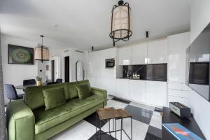 巴黎O'Lord, 4 Etoiles, Residence de Luxe Champs-Elysees的一间带绿色沙发的客厅和一间厨房
