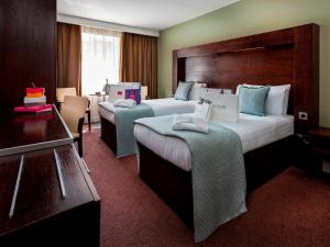 恩尼斯科西Treacy's Hotel Wexford的酒店客房设有两张床和一张桌子。