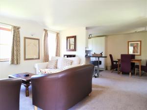 LlanfyrnachWellstone Cottages - Honeysuckle的客厅配有沙发和桌子