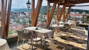 拉姆尼库沃尔恰Simfonia Boutique Hotel的阳台餐厅,配有桌椅