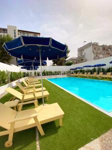 巴里维多利亚公园酒店 的一个带躺椅和遮阳伞的游泳池