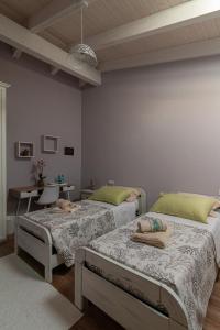 MarrùbiuLa Vecchia Dimora的客房设有两张床、一张桌子和一张书桌