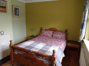 法伦福尔Hannah's Cottage的一间卧室配有一张带 ⁇ 面毯的木床