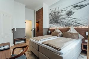 博尔库姆霍亨索伦海滩酒店的一间卧室配有一张床、一张桌子和一张书桌