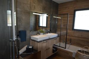 穆然Les villas du Golf Mougins的浴室配有2个盥洗盆、淋浴和浴缸。